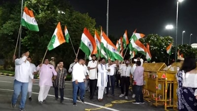 People wave the Indian national flags as they wait to welcome Astronaut Shubhanshu Shukla ahead of his arrival at the Indira Gandhi International (IGI) Airport, in New Delhi, early Sunday. (PTI)