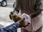 A sales assistant hands produce to a customer at a grocery store, known as a kirana, in Bengaluru, India, on Monday, Jun. 21, 2021.