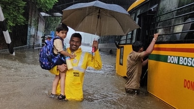 A Mumbai police personnel smiles at the camera while he rescues a child stuck in a school bus in Matunga today, after IMD issued a red alert for heavy showers in the city. (Yogesh Naik/Hindustan Times) A Mumbai police personnel smiles at the camera while he rescues a child stuck in a school bus in Matunga today, after IMD issued a red alert for heavy showers in the city. (Yogesh Naik/Hindustan Times)