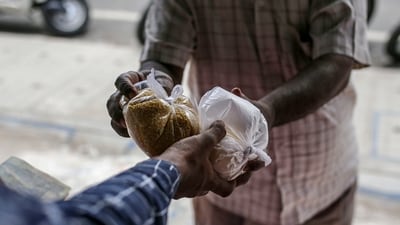 A sales assistant hands produce to a customer at a grocery store, known as a kirana, in Bengaluru, India, on Monday, Jun. 21, 2021. (Bloomberg) A sales assistant hands produce to a customer at a grocery store, known as a kirana, in Bengaluru, India, on Monday, Jun. 21, 2021. (Bloomberg)