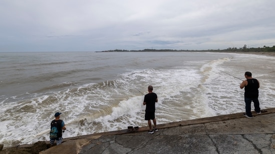 People fish along the shore in Arecibo, Puerto Rico, as Hurricane Erin brings rains to the island, Sunday, Aug. 17, 2025. (AP Photo/Alejandro Granadillo) (AP)