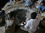 Rescue workers and residents search for victims in the debris of collapsed houses after a cloudburst in Dolari village in Pakistan's Swabi district on August 18, 2025.