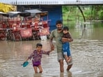 People passing through the flooded river water after the rise in the Yamuna water levels on Tuesday. (Sanchit Khanna/Hindustan Times)