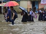 School students make their way through water logged on Tilak Rd, near Khodadad Cricle at Dadar TT, in Mumbai.