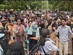 Women students agitating at the Bab-e-Syed gate of AMU on Monday. (HT) Women students agitating at the Bab-e-Syed gate of AMU on Monday. (HT)