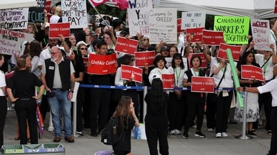 Striking Air Canada flight attendants hold placards as they defy a back to work order at Vancouver International Airport in Richmond, British Columbia, Canada (REUTERS)