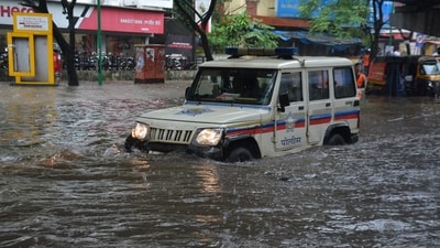 A Mumbai Police vehicle wade through a waterlogged road as the city battles intense rain since Friday. (Praful Gangurde/Hindustan Times)