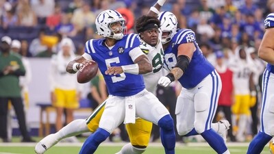 Anthony Richardson Sr. #5 of the Indianapolis Colts drops back to pass under pressure from Warren Brinson #91 (Getty Images via AFP)