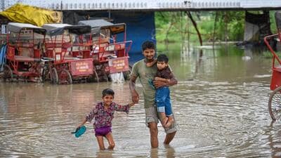 People passing through the flooded river water after the rise in the Yamuna water levels on Tuesday. (Sanchit Khanna/Hindustan Times) People passing through the flooded river water after the rise in the Yamuna water levels on Tuesday. (Sanchit Khanna/Hindustan Times)
