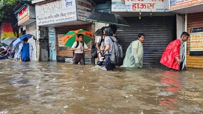 Mumbai rain: People wade through a waterlogged road after heavy rain, at King Circle, Mumbai on Monday. (ANI) Mumbai rain: People wade through a waterlogged road after heavy rain, at King Circle, Mumbai on Monday. (ANI)