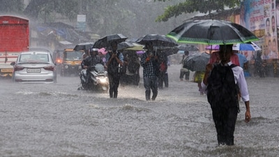 Mumbai: Commuters make way through a waterlogged road amid rainfall, in Mumbai, Tuesday, Aug. 19, 2025. (PTI Photo)(PTI08_19_2025_000449B) (PTI)