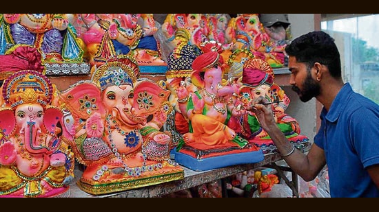An artist giving final touches to Ganesha idols in Ludhiana on Wednesday. (Manish/HT)