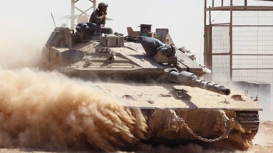 Israeli troops drive a tank near Israel’s border fence with the Gaza Strip.