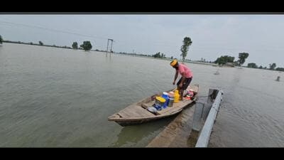 A man carries essentials in a boat on Thursday. (HT) A man carries essentials in a boat on Thursday. (HT)