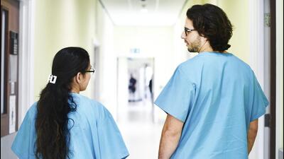 Colleagues walking down the hospital corridor Colleagues walking down the hospital corridor