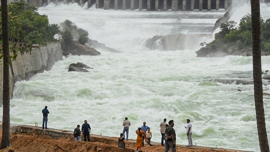 People watch water discharge from KRS reservoir, in Mandya district, Karnataka, on Monday (PTI)