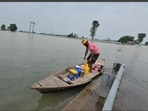A man carries essentials in a boat on Thursday. (HT)