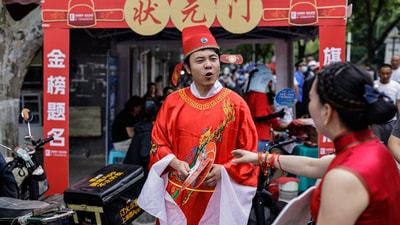 A volunteer in the costume of an ancient Chinese scholar gives blessings for gaokao test-takers in Wuhan, China, June 7, 2023. A volunteer in the costume of an ancient Chinese scholar gives blessings for gaokao test-takers in Wuhan, China, June 7, 2023.