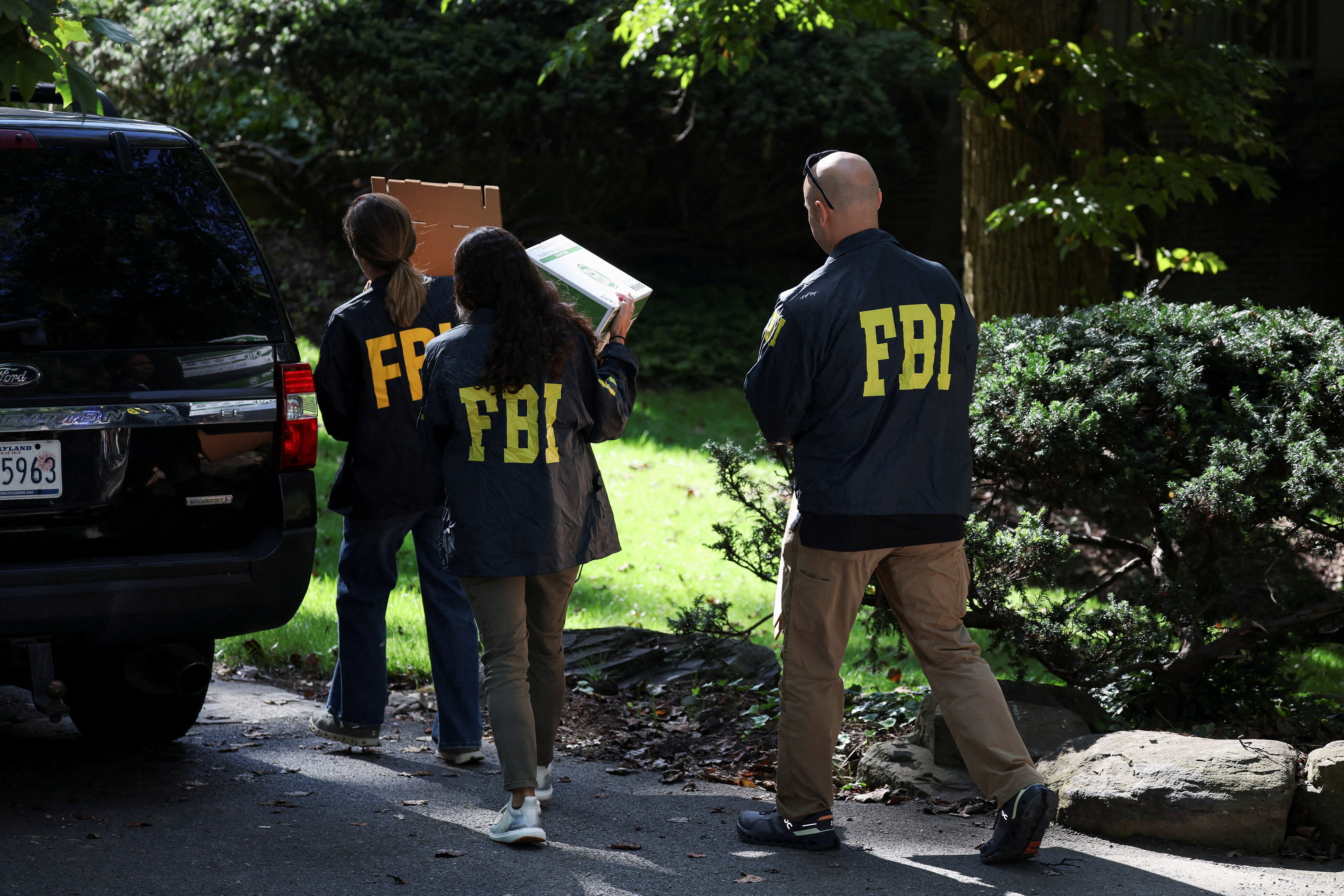 FBI members carry boxes to the home of the former White House national security adviser John Bolton as it is searched by FBI, in Bethesda, Maryland, U.S. (Reuters)