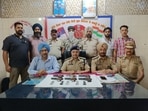 Police officials with the seized firearms and ammunition along with the accused at Ludhiana railway station. (HT Photo)