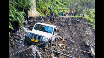 A vehicle being lifted from the debris of a damaged road after heavy rainfall, in Kullu district, on Saturday. (PTI)