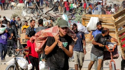 People walk with bags of humanitarian aid they received at a distribution centre run by the US and Israeli-backed Gaza Humanitarian Foundation (GHF), (AFP) People walk with bags of humanitarian aid they received at a distribution centre run by the US and Israeli-backed Gaza Humanitarian Foundation (GHF), (AFP)