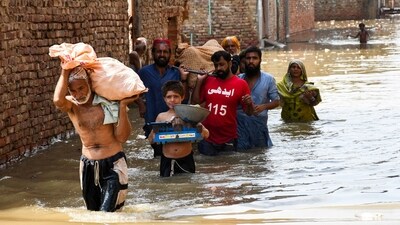 People wade through a flooded street as they carry a woman towards the hospital at Latifabad, Hyderabad, Pakistan, August 22, 2025. (REUTERS)