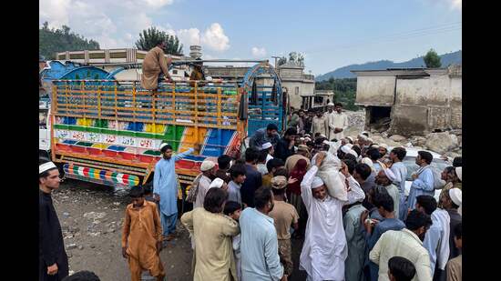 Flash flood affected people gather to receive food in the Buner district of Pakistan’s Khyber Pakhtunkhwa province on Saturday. (AFP)