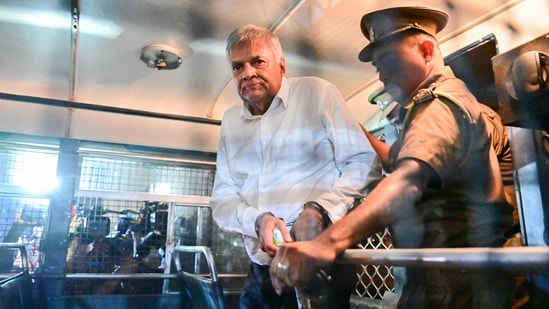Sri Lanka's former president Ranil Wickremesinghe is escorted to his seat in a prison bus in Colombo on August 22, 2025. (AFP)