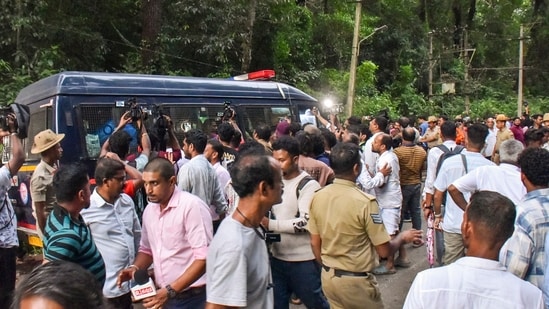 People gather near a site of an alleged burial related to the Dharmasthala mass burial case, at Dharmasthala, in Dakshina Kannada district. (PTI)