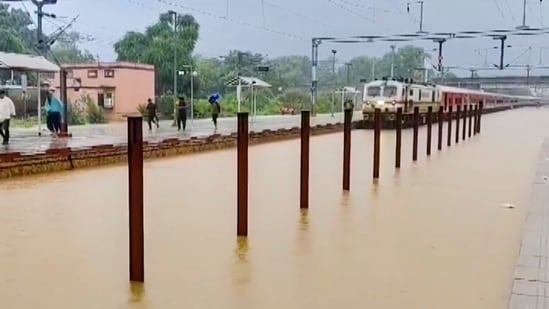 A train passes on railway tracks submerged in floodwater due to heavy rainfall, at a station, in Sawai Madhopur, Rajasthan, Friday, Aug. 22, 2025 (PTI )