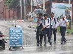 School students walk holding an umbrella during heavy rainfall, in Jammu on Saturday. (ANI) School students walk holding an umbrella during heavy rainfall, in Jammu on Saturday. (ANI)