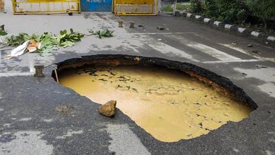 A portion of a road caved in after heavy rainfall at Dwarka in New Delhi on Sunday. (PTI) A portion of a road caved in after heavy rainfall at Dwarka in New Delhi on Sunday. (PTI)