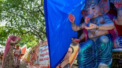 An idol of lord Ganesh and a devotee exchange glances from under their veils in New Delhi's Mayur Vihar as the country decks up for Ganpati celebrations. (Salman Ali/PTI) An idol of lord Ganesh and a devotee exchange glances from under their veils in New Delhi's Mayur Vihar as the country decks up for Ganpati celebrations. (Salman Ali/PTI)