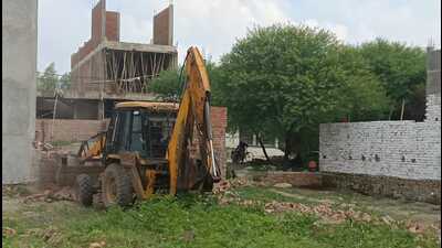 PDA bulldozer demolishes boundary wall of illegal plots in Zone VI, Prayagraj. (HT) PDA bulldozer demolishes boundary wall of illegal plots in Zone VI, Prayagraj. (HT)