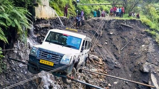 A vehicle being lifted from the debris of a damaged road after heavy rainfall, in Kullu district, Himachal Pradesh on Saturday, August 23, 2025. (PTI)