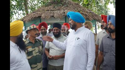 AAP MLA from Ajnala and former cabinet minister Kuldeep Singh Dhaliwal interacting with BSF officials about the flood situation in Ravi river on Monday. (HT)