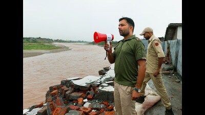 Police personnel prepare to warn and evacuate people from near Tawi river following heavy rainfall, in Jammu, on Monday. (PTI) Police personnel prepare to warn and evacuate people from near Tawi river following heavy rainfall, in Jammu, on Monday. (PTI)