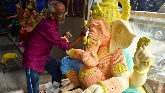 An artist uses coloured chalk sticks to make Ganpati idol, at a Ganesh workshop, Chinchpokli, in Mumbai, India, on Thursday. (Bhushan Koyande/HT Photo)