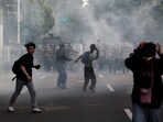 Protesters react as they clash with riot police during a protest against, what the demonstrators say, are exorbitant allowances for Indonesian parliament members