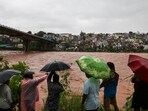 People look at the swollen Tawi river amid rainfall, in Jammu, Tuesday, Aug. 26, 2025.