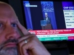A specialist trader works on the floor at the New York Stock Exchange as a screen shows Federal Reserve Chairman Jerome Powell speaking during the Jackson Hole conference, in New York City, U.S., August 22,