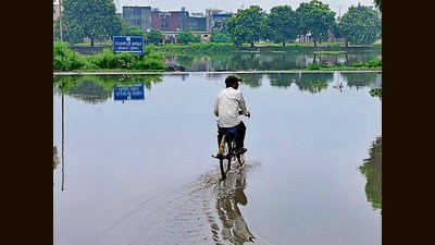A cyclist pedals through a waterlogged stretch in Moti Nagar after heavy rain. (Gurpreet Singh/HT)