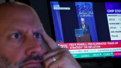 A specialist trader works on the floor at the New York Stock Exchange as a screen shows Federal Reserve Chairman Jerome Powell speaking during the Jackson Hole conference, in New York City, U.S., August 22, (REUTERS)