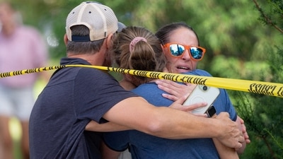 Families and loved ones reunite outside the police barricades after a shooting at Annunciation Church (REUTERS)