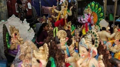 A girl sits amidst idols of the Hindu god Ganesh inside a workshop on the eve of the ten-day-long Ganesh Chaturthi festival in Mumbai (Reuters)