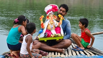 A man carries an idol of Lord Ganesha on a boat with children on the eve of the Ganesh Chaturthi festival, in Balurghat, West Bengal. (PTI) A man carries an idol of Lord Ganesha on a boat with children on the eve of the Ganesh Chaturthi festival, in Balurghat, West Bengal. (PTI)