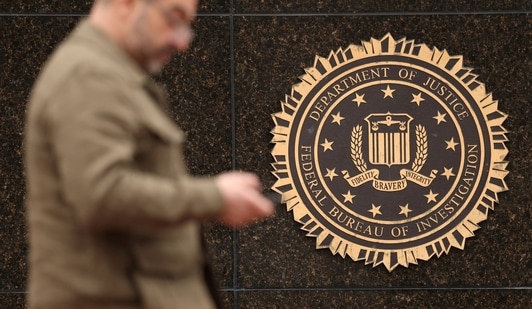 A person passes by the FBI seal on the wall of the FBI headquarters, in Washington, U.S., February 3 (REUTERS)