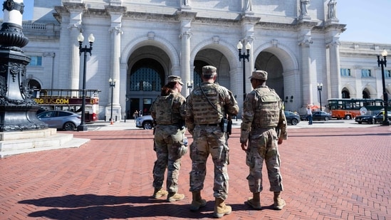 Armed members of the National Guard patrol outside of Union Station in Washington DC. (AFP)