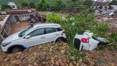 Two cars are seen struck in flood debris after the waters of Tawi rose due to heavy rains in Jammu since Tuesday. (PTI) Two cars are seen struck in flood debris after the waters of Tawi rose due to heavy rains in Jammu since Tuesday. (PTI)